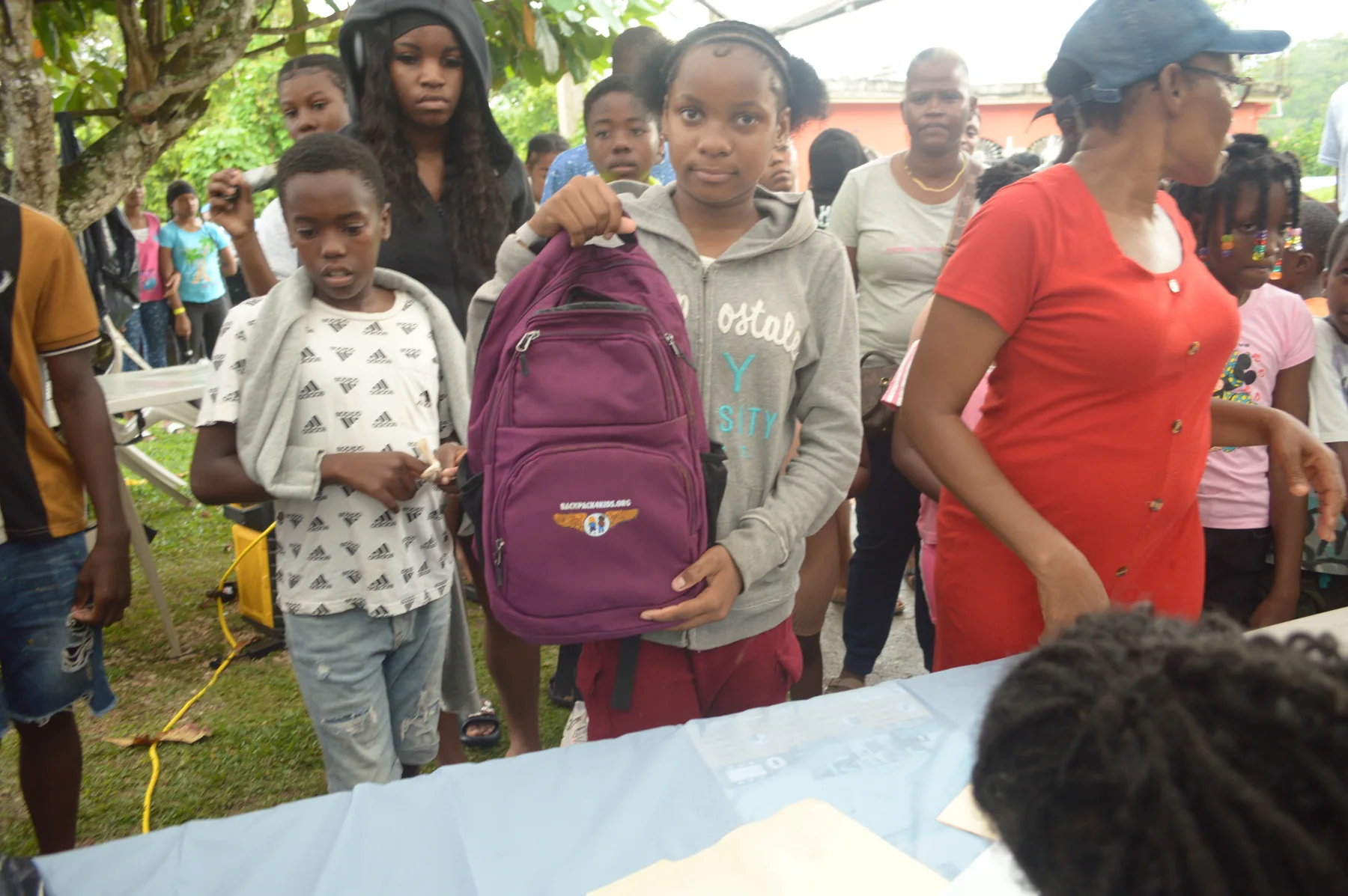 A child receiving a purple backpack